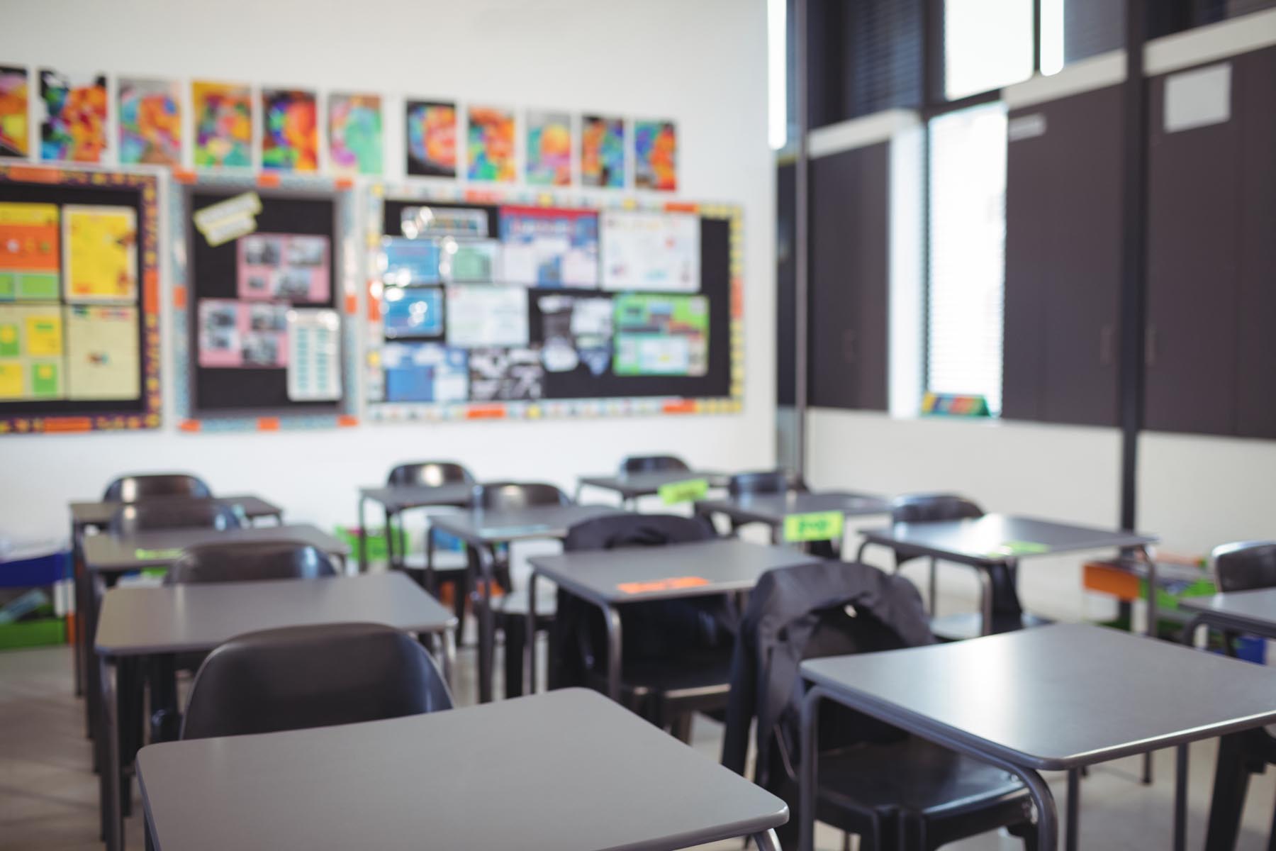 Interior of empty classroom with desks and chairs