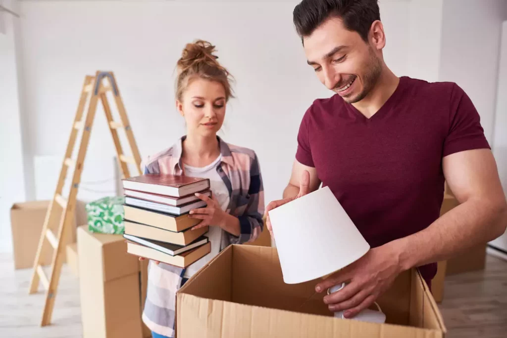 Couple packing a lamp into a box