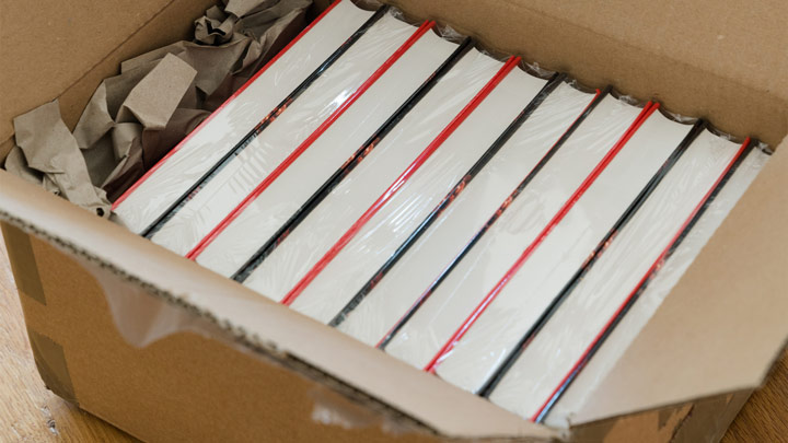 A stack of books packed into a box ready for moving.