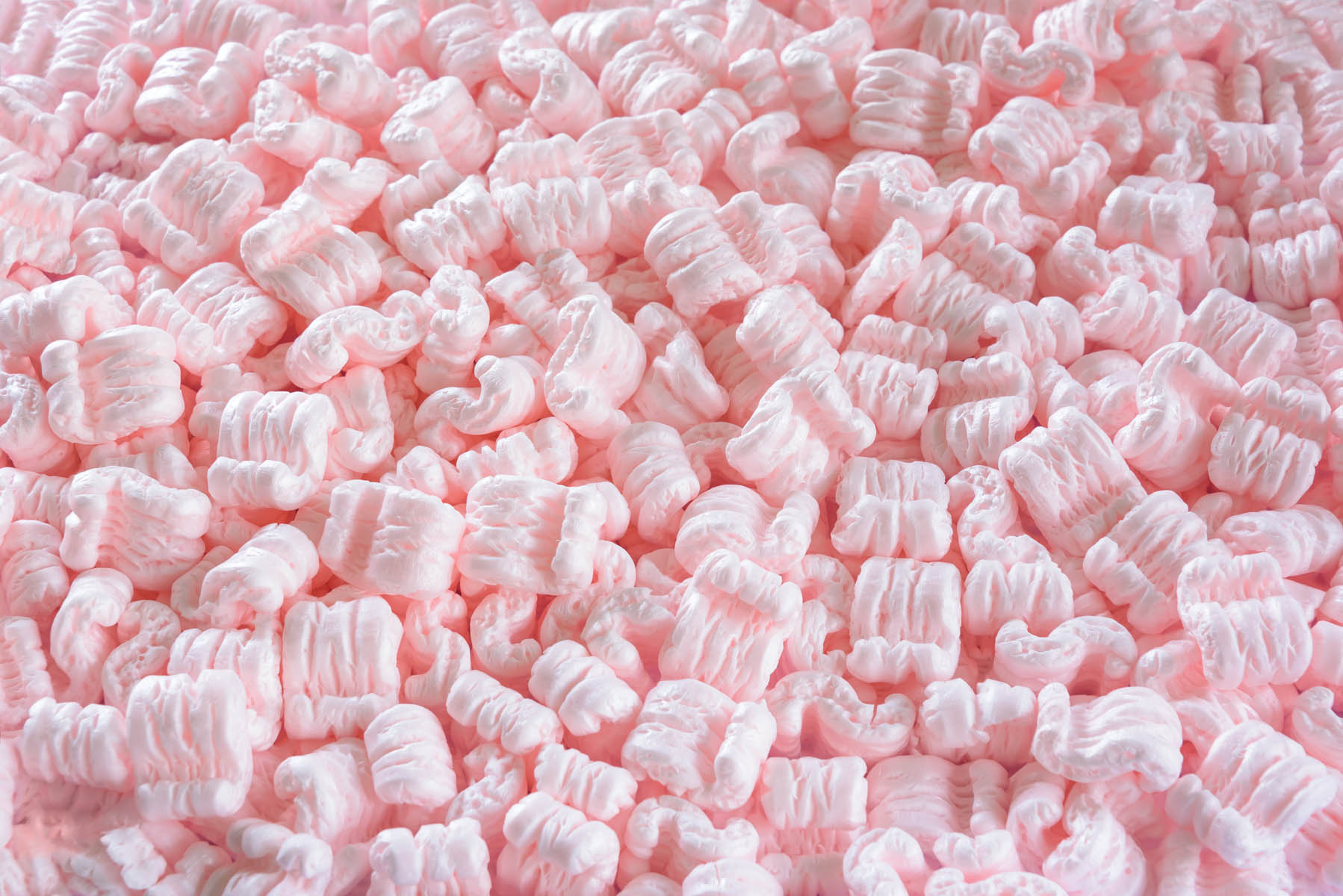 S-shaped pink packing peanuts as a background