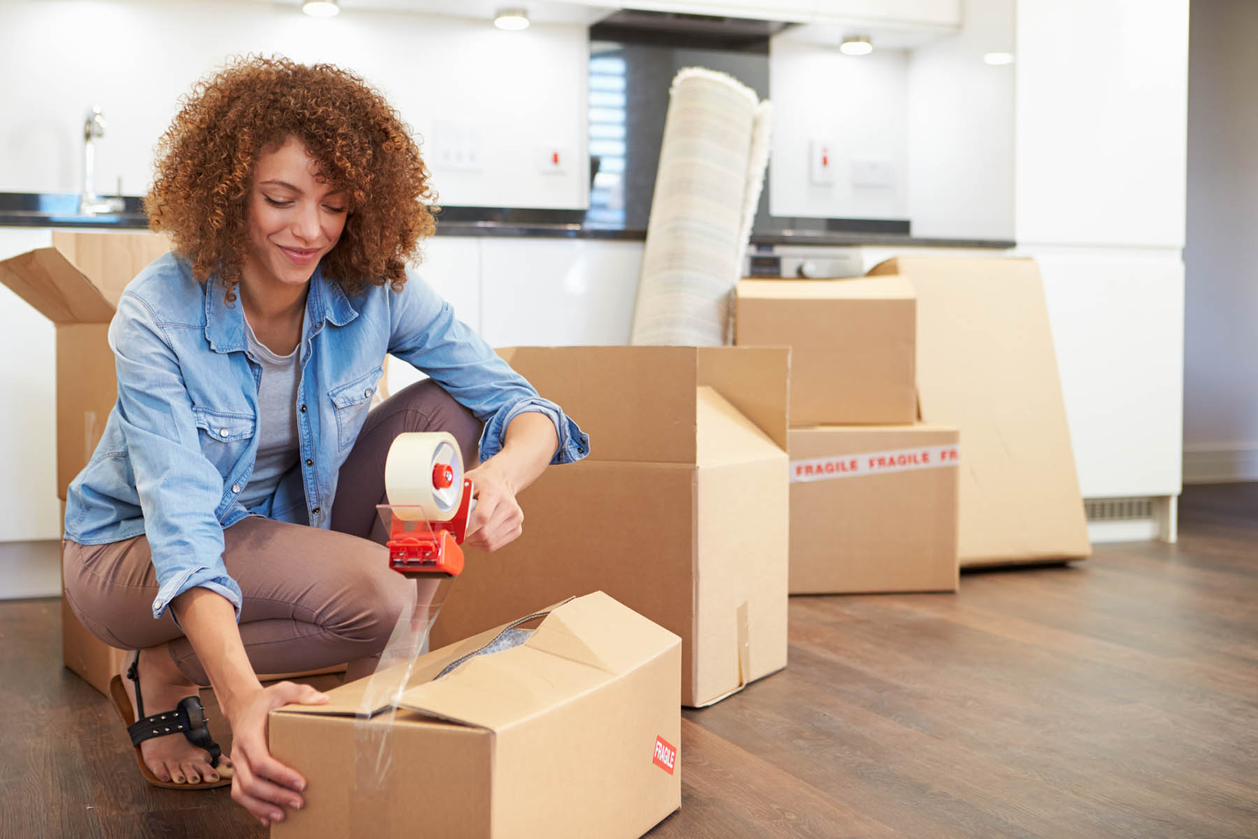 Woman Sealing Boxes Ready For House Move